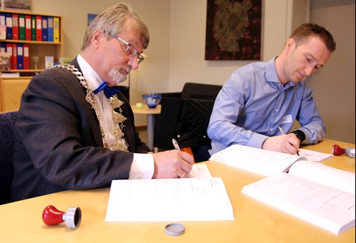 Fylkesordfører Knut Werner Hansen signerer kontrakten sammen med Stian  Andreassen, anleggsdirektør i Lemminkäinen Norge